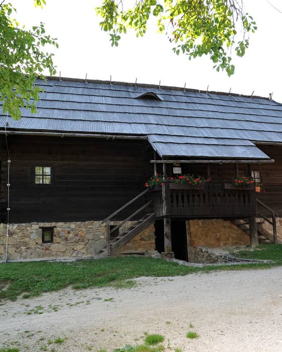 The exterior of Prežihov's Cottage with its characteristic wooden construction and stone base