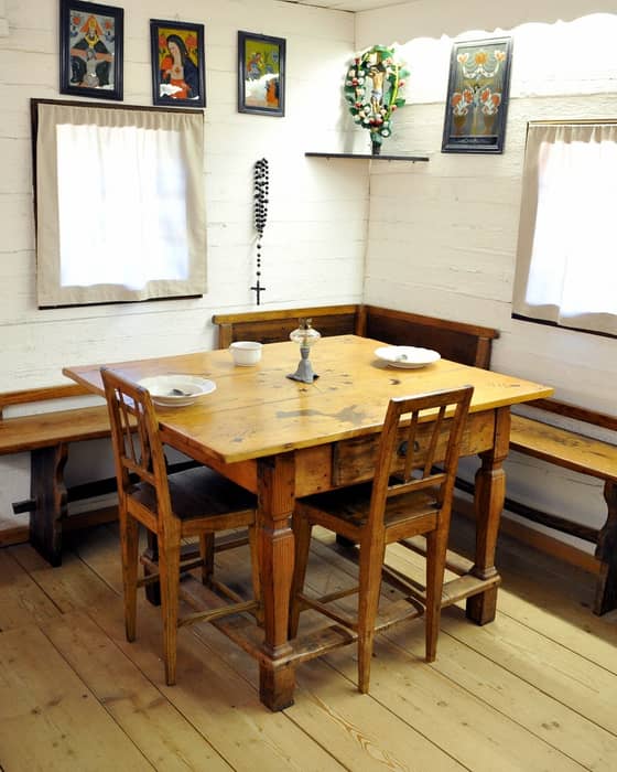 A traditional living room in Prežihov's Cottage with a wooden table, chairs and benches