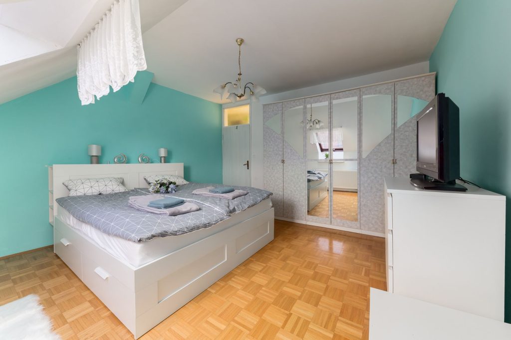 Bright and spacious bedroom with a comfortable double bed and large wardrobe.