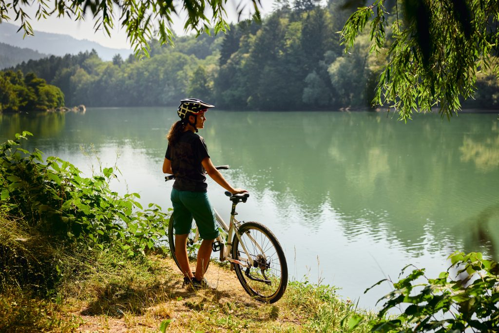A cyclist enjoying a peaceful stop in the midst of nature, observing the Drava River.