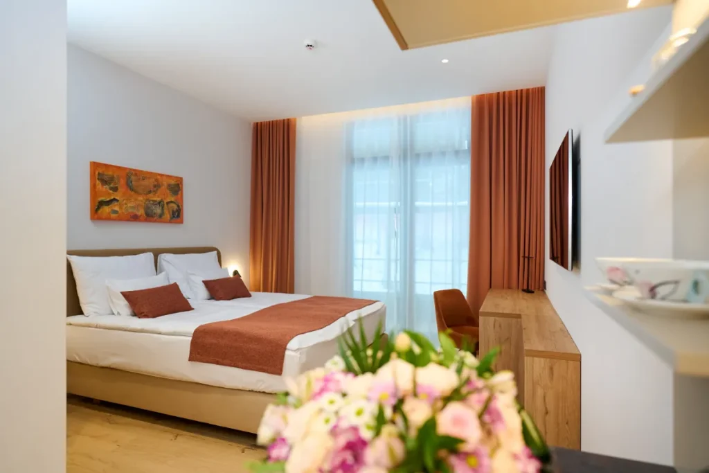 Sodobno opremljena hotelska soba v Hotelu Wada, zasnovana v toplih naravnih tonih in z elegantnimi lesenimi detajli.