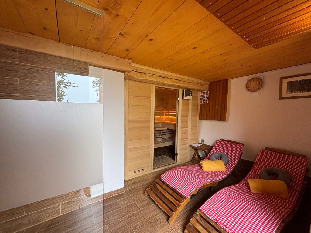 The wellness area offers relaxation in a warm wooden ambience with a sauna and comfortable loungers.