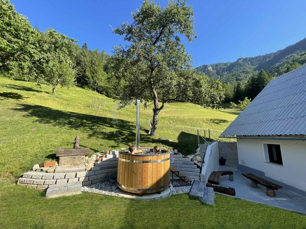 A pleasant corner for relaxation in a wooden hot tub, surrounded by green meadows.