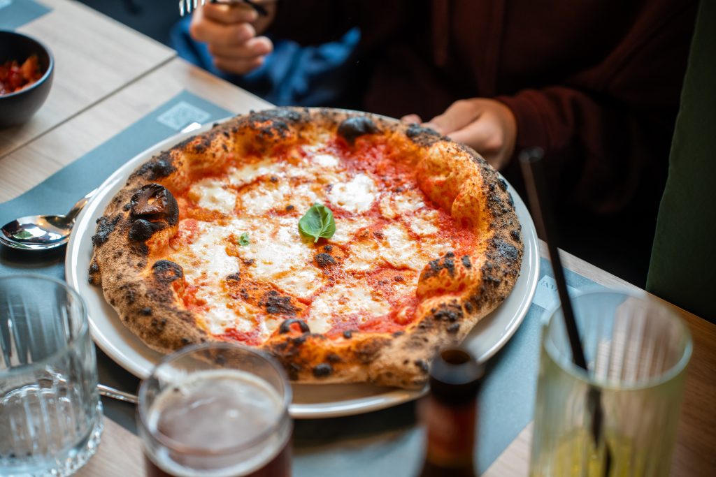 Hrustljava skorja, sveža bazilika, paradižnikova omaka in kakovostni dodatki ustvarjajo pristno italijansko pico, pripravljeno po tradicionalnem postopku v krušni peči.
