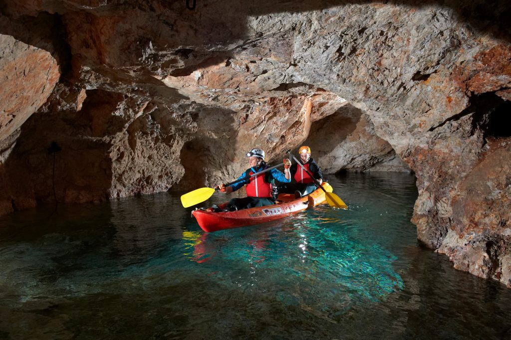 Two visitors explore the flooded mine shafts of Peca Underground by kayak.