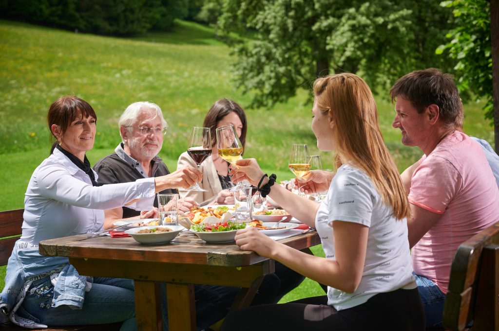 Guests enjoying homemade delicacies and pleasant company outdoors.