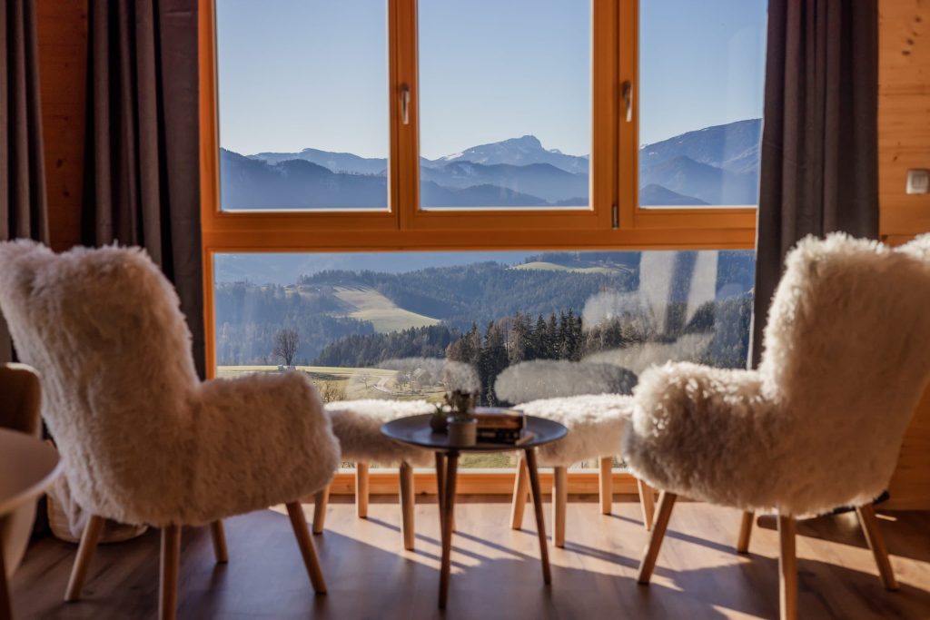 The interior of the studio with panoramic views, comfortable armchairs, and natural details, creating a pleasant ambiance for rest and relaxation.