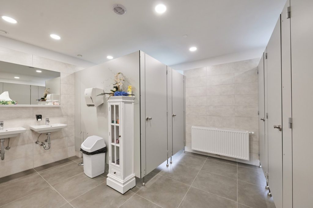 Modernly arranged shared sanitary facilities with several separate cubicles and washbasins.