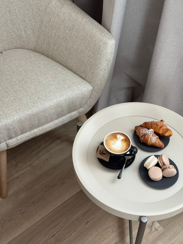 A coffee table with a cup of coffee, cookies, and two fresh croissants for a pleasant moment of indulgence.