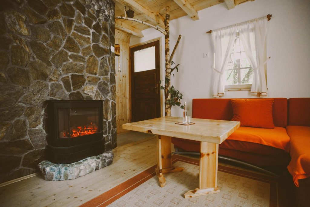 A cozy corner by the fireplace, where wood, stone, and the homeliness of an authentic Koroška tourist farm come together.