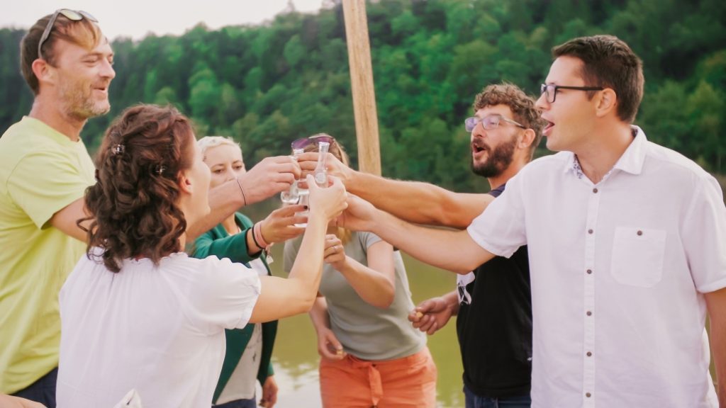 Socialising and toasting on the Drava River, where, with a glass in hand, smiles, and good cheer, memories of an authentic rafting experience are made.