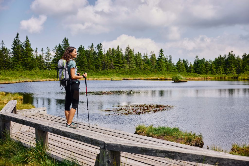 A hiker by Ribniško Lake in Pohorje – an idyllic stop amidst unspoiled nature, surrounded by forests and marshland.