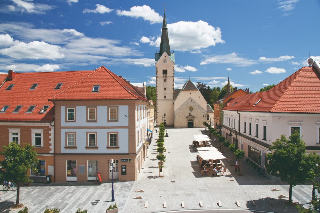 The main square in Slovenj Gradec – a place of gathering, culture, and urban life, where historic buildings tell stories of the past. St. Elizabeth's Church in the background.  