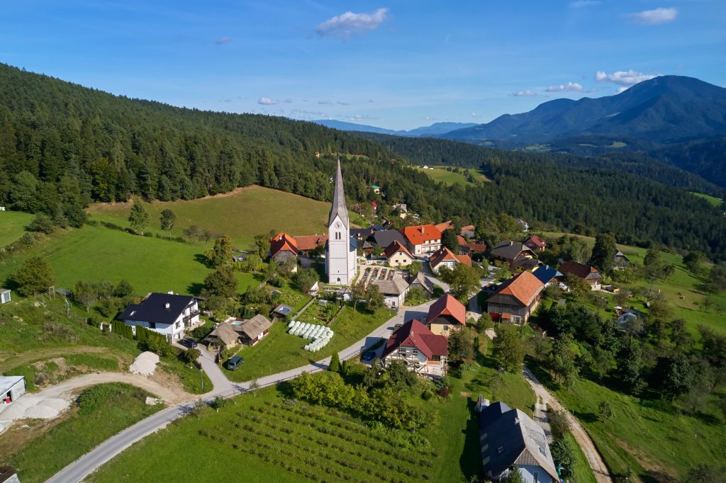 Hribovska vas nad Prevaljami, kjer se prepletajo značilna koroška krajina, domačnost podeželja in razgledi na mogočne okoliške gore.