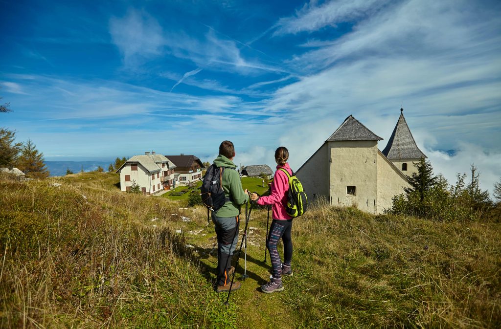 Pohodnika ob cerkvi sv. Uršule na Uršlji gori, eni najbolj prepoznavnih pohodniških točk Koroške.