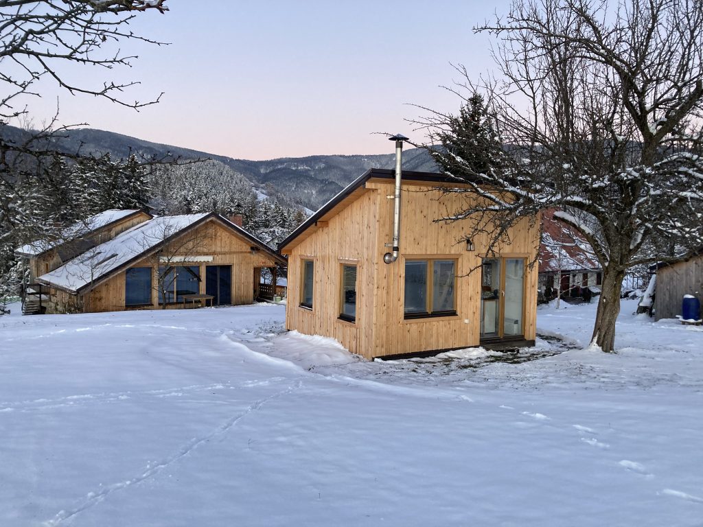 Buildings surrounded by snow and the peaceful nature of Pohorje.