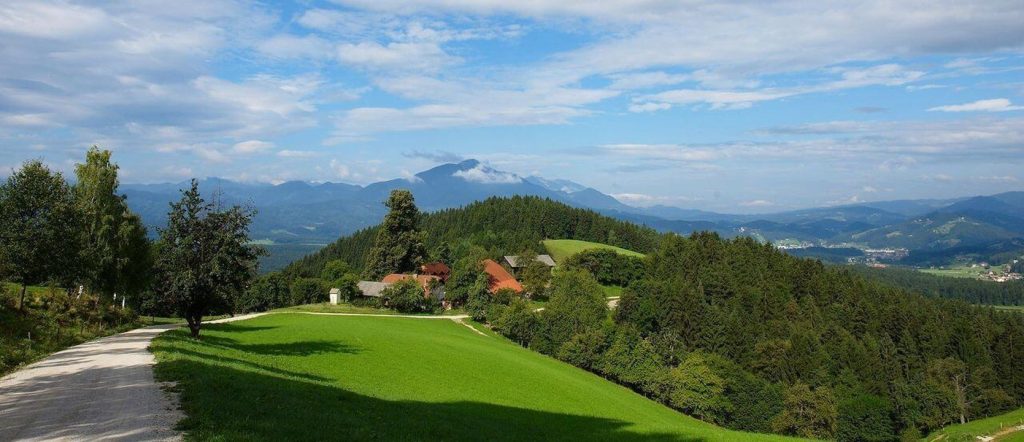 Razgled s kmetije Lešnik – zelena pokrajina Pohorja, obdana z gozdovi, travniki in pristnimi koroškimi domačijami.