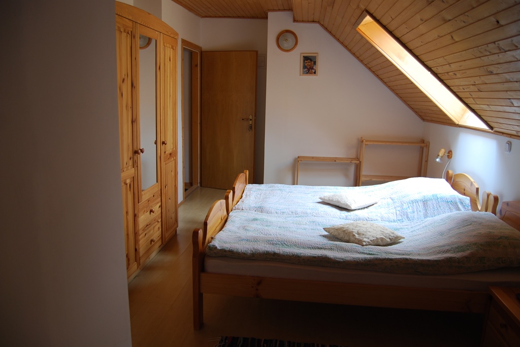 A spacious attic room offers a comfortable rest in the heart of the Koroška countryside.