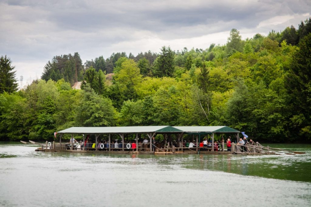 Cruising on the Drava River on a traditional raft, surrounded by green forests and the beautiful nature of the Drava Valley.