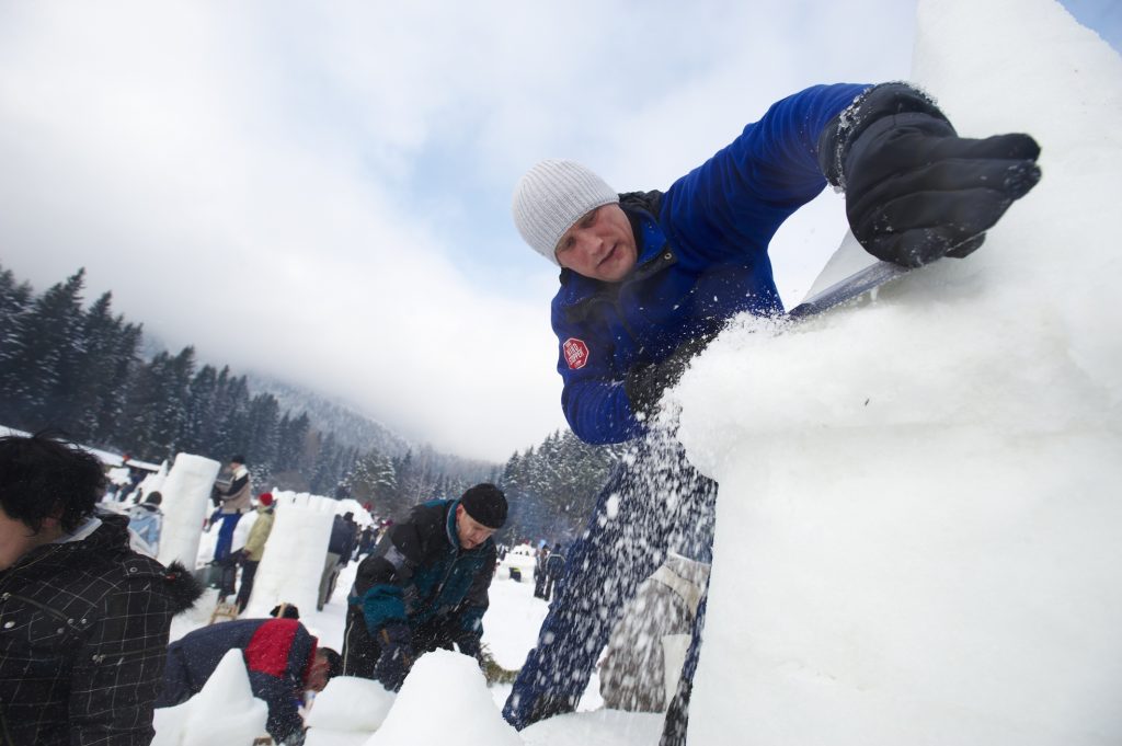 Shaping an ice sculpture with a saw.