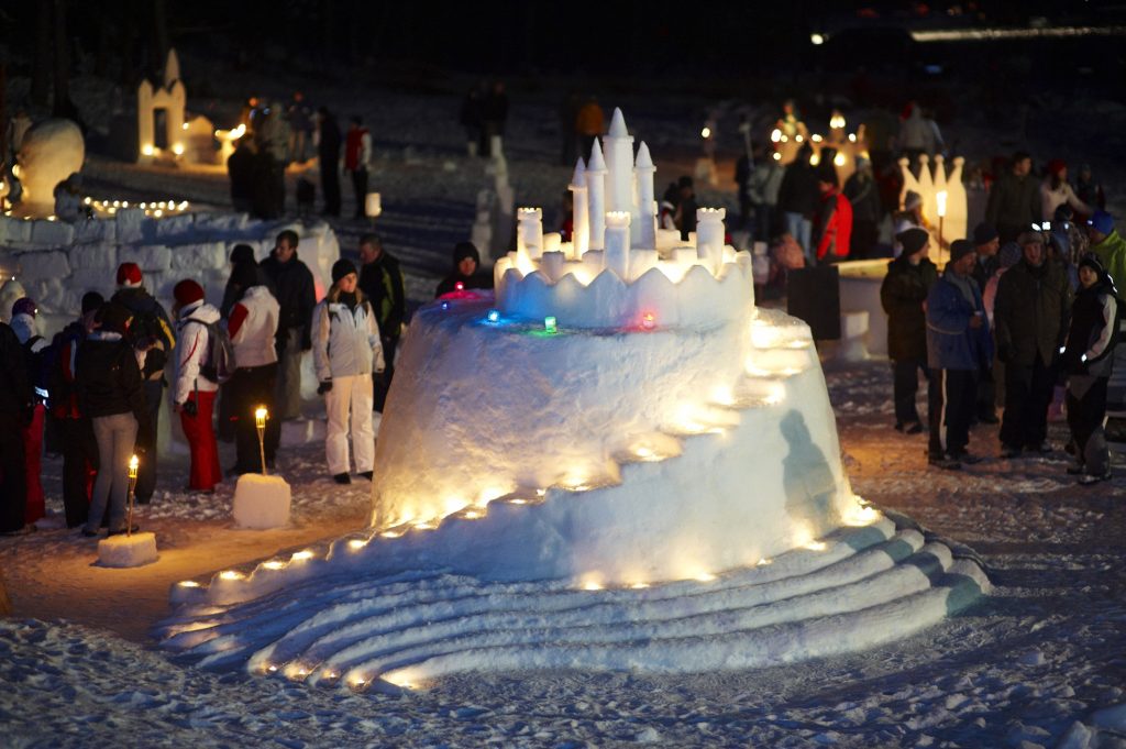 Visitors admiring the magically illuminated snow castles.