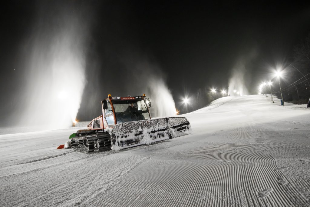Snow cannons and a snow groomer keep the ski slope well maintained.