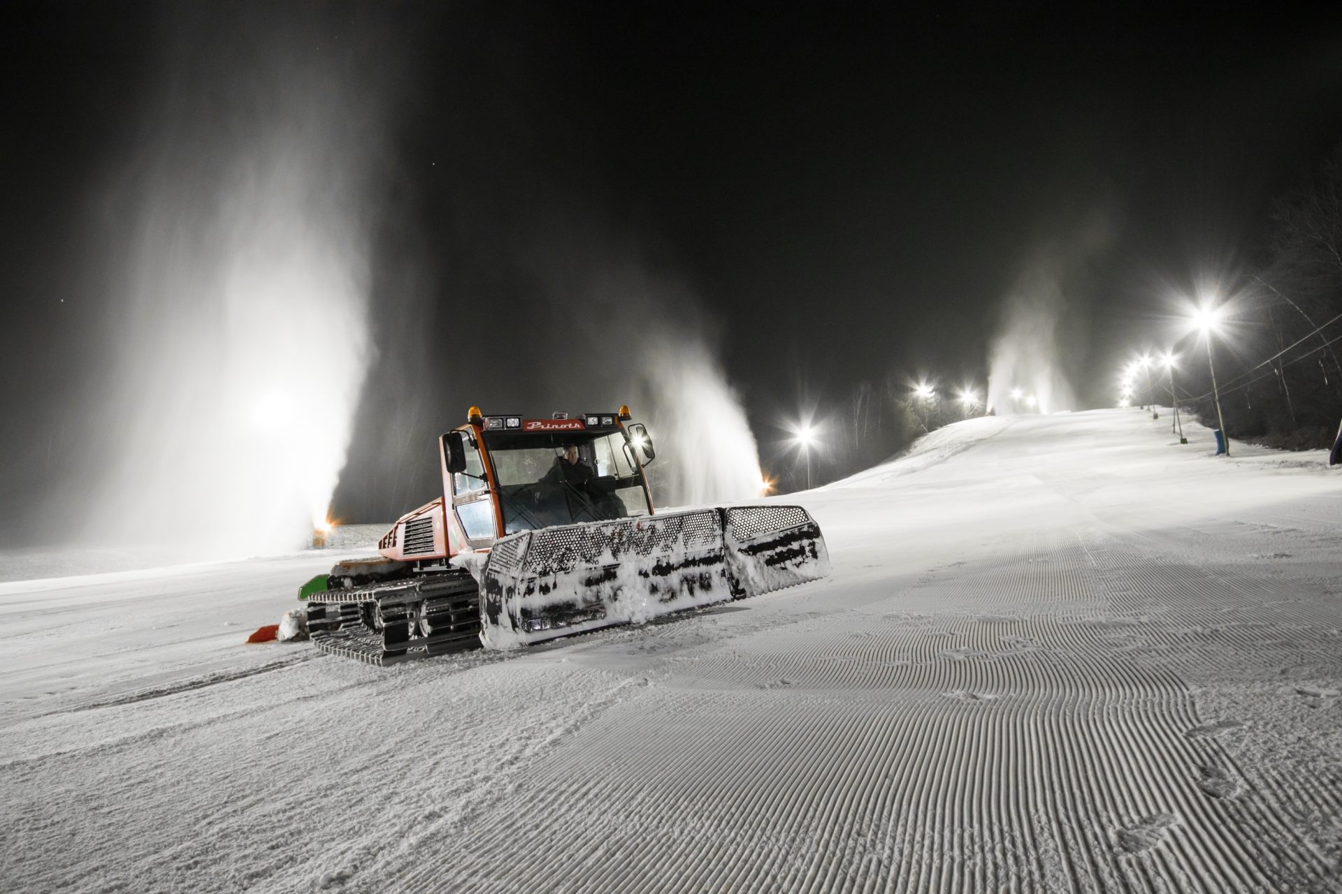 Snow cannons and a snow groomer keep the ski slope well maintained.