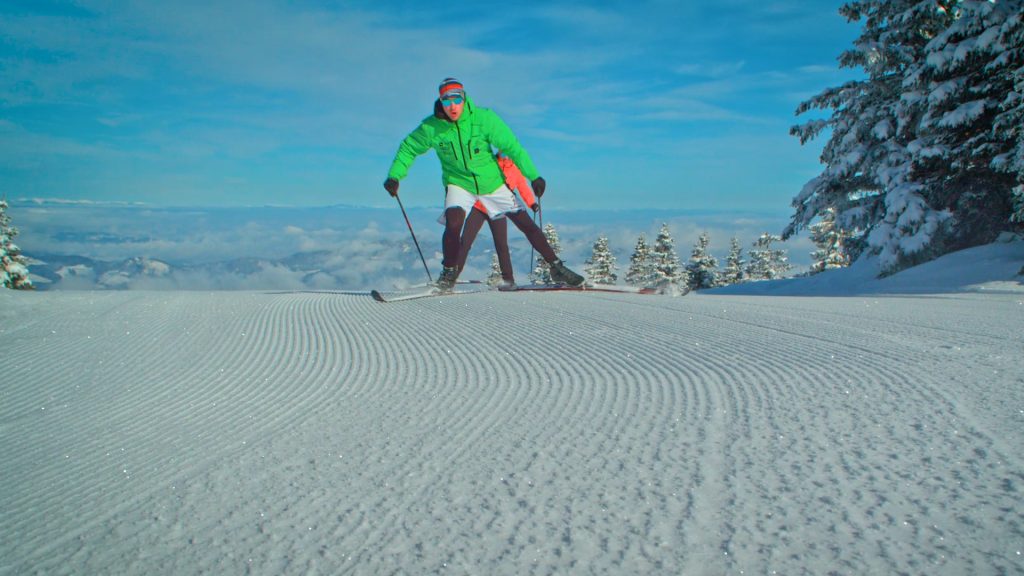 Two cross-country skiers in vigorous motion through the snow.