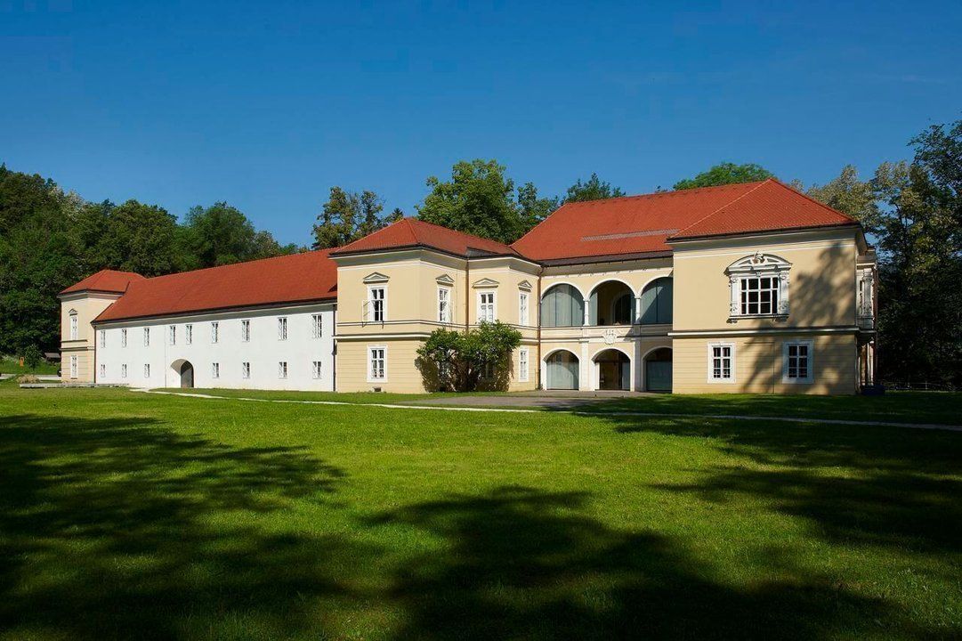 Ravne Castle, home to the Koroška Central Library, embraced by a well-kept park.