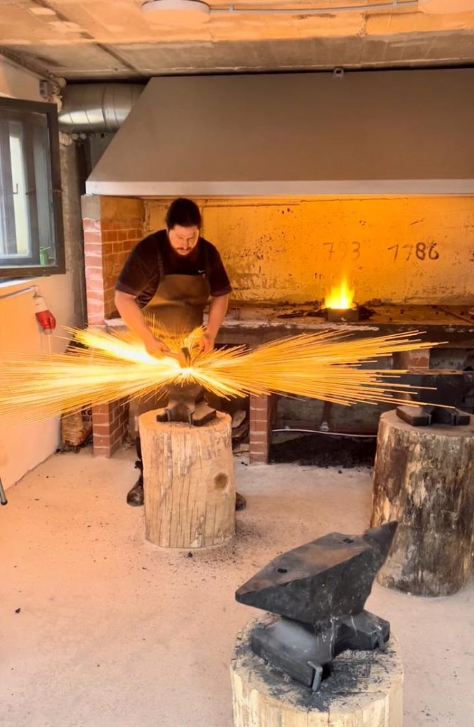 A blacksmith at work in the blacksmith's workshop, where sparks fly during welding.