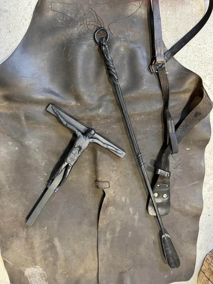 Blacksmith's products – a metal crucifix, a cross with a depiction of Jesus Christ, and a shoehorn.