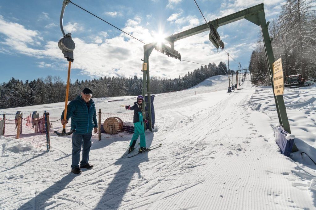 Helping a skier grasp the tow handle on the Poseka drag lift.