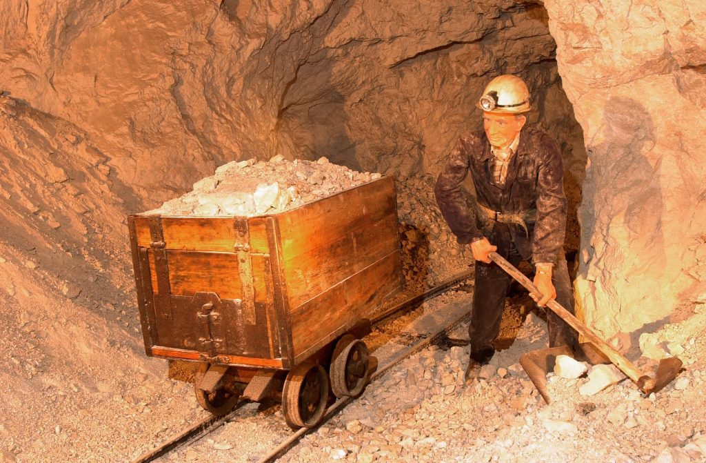 Demonstration of mining work – a miner mannequin loads the excavated ore into a cart.