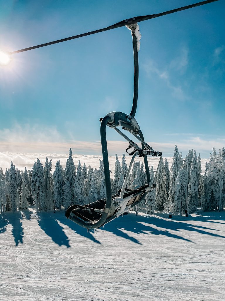 Chairlift above a snow-covered slope in sunny weather.
