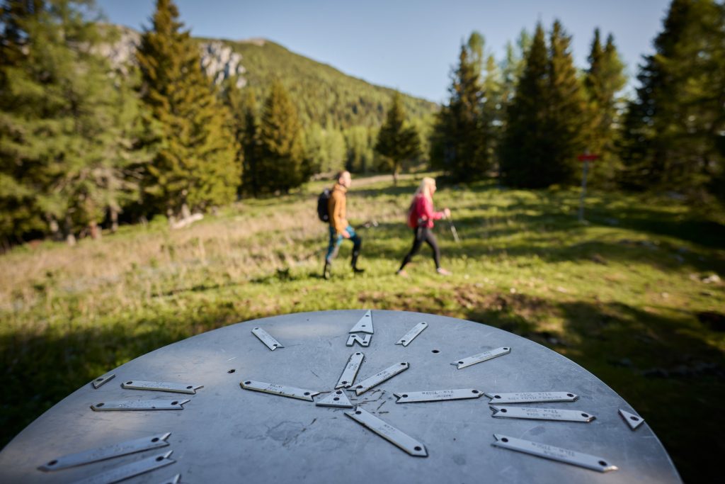 At the summit, hikers are greeted by a panoramic viewing platform and a view of the surrounding mountain world.