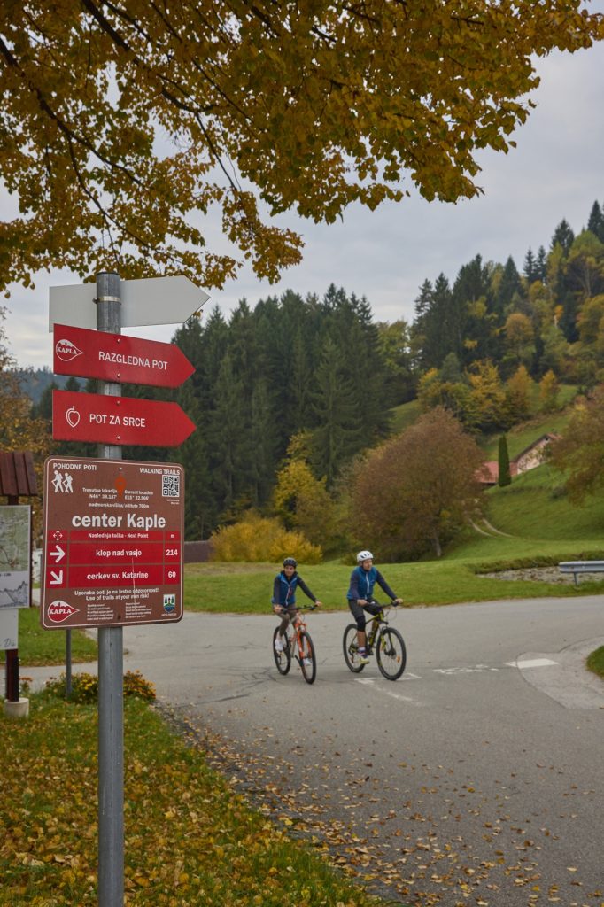 Along the paved road through Kapla, where a signpost shows the way forward.