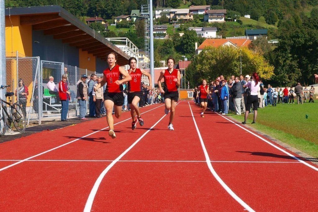 Tekaško tekmovanje mladih atletov na stadionu.
