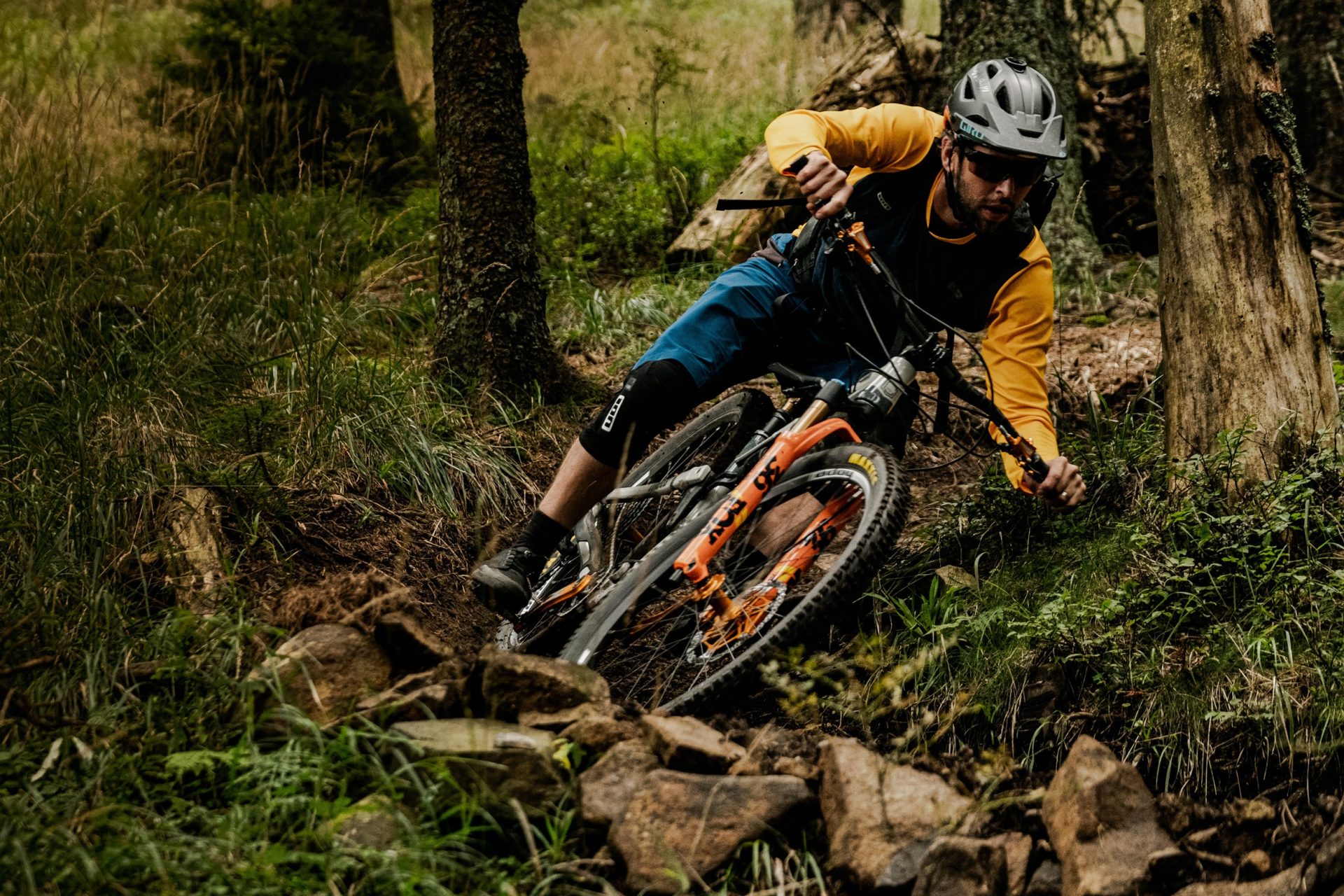 Mountain biker on a challenging and steep MTB trail through the forest.