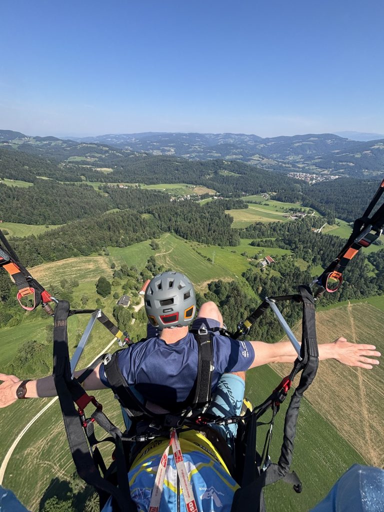 An aerial view during a tandem flight over a green landscape.