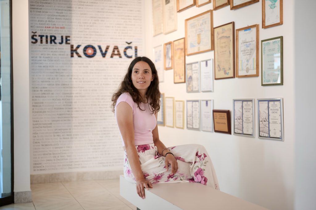 A visitor discovering the story of Štirje kovači through awards, photographs, and memories of their musical journey.