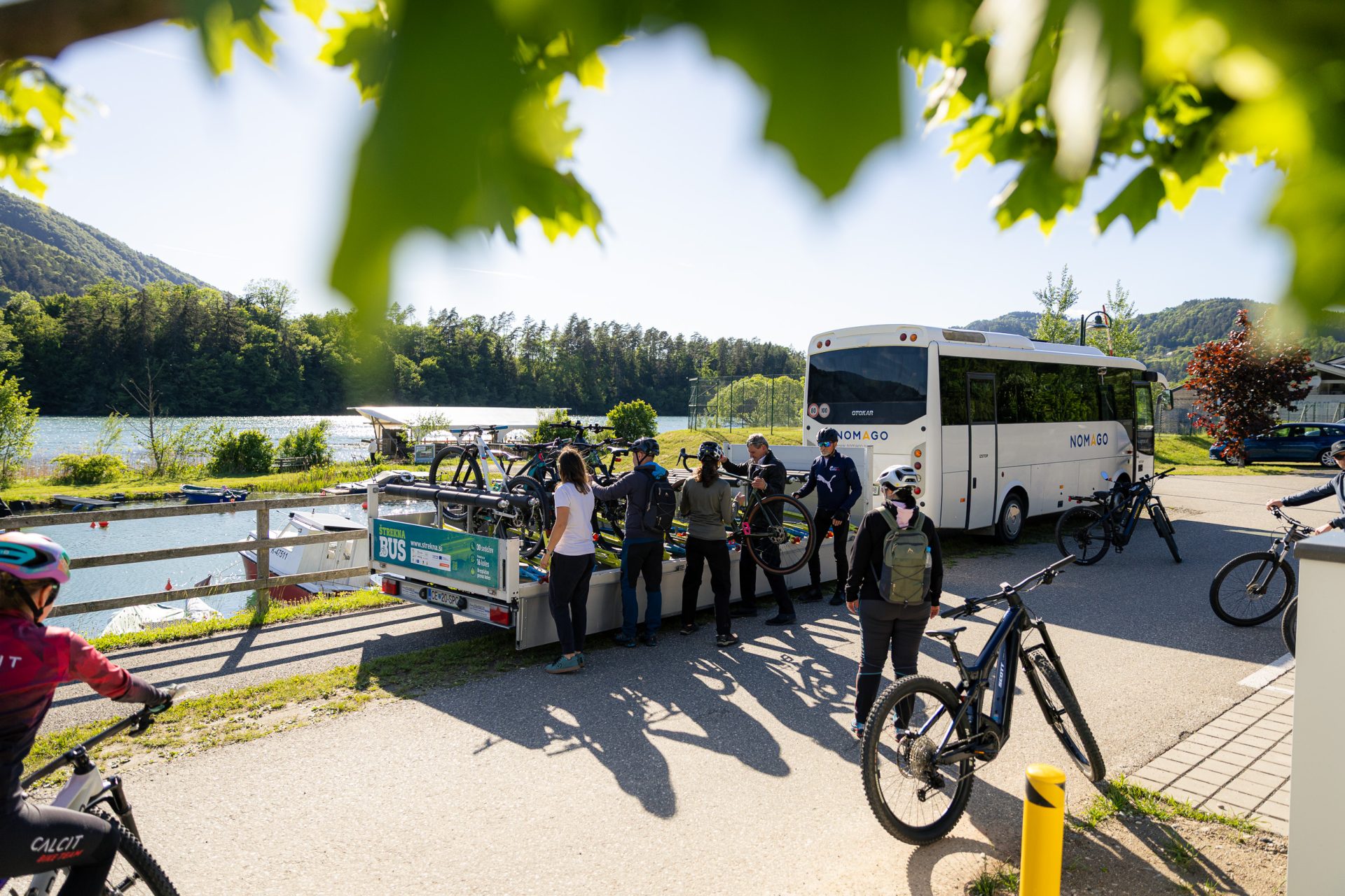 Kolesarji ob prihodu prevzemajo kolesa iz prikolice avtobusa.