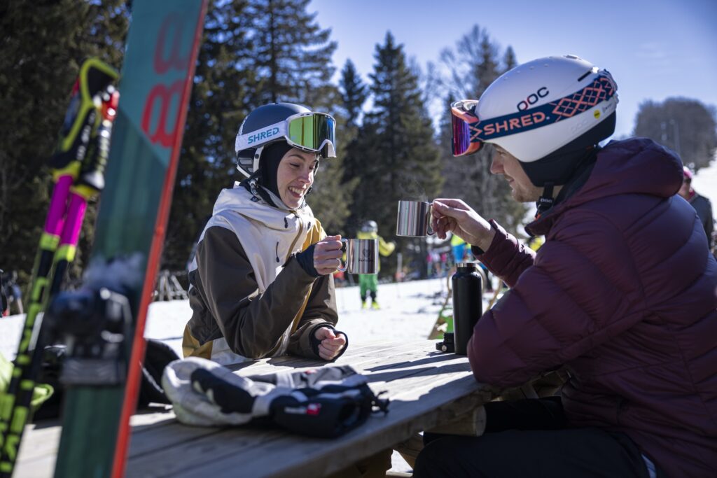 Two skiers at a ski resort in Koroška toasting with tea